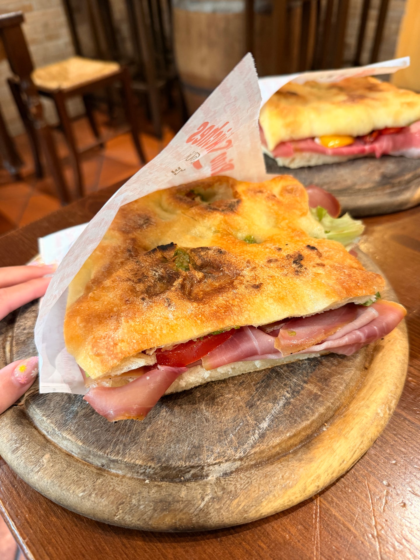 Two freshly made panini served on wooden boards at Pino's Sandwiches in Florence
