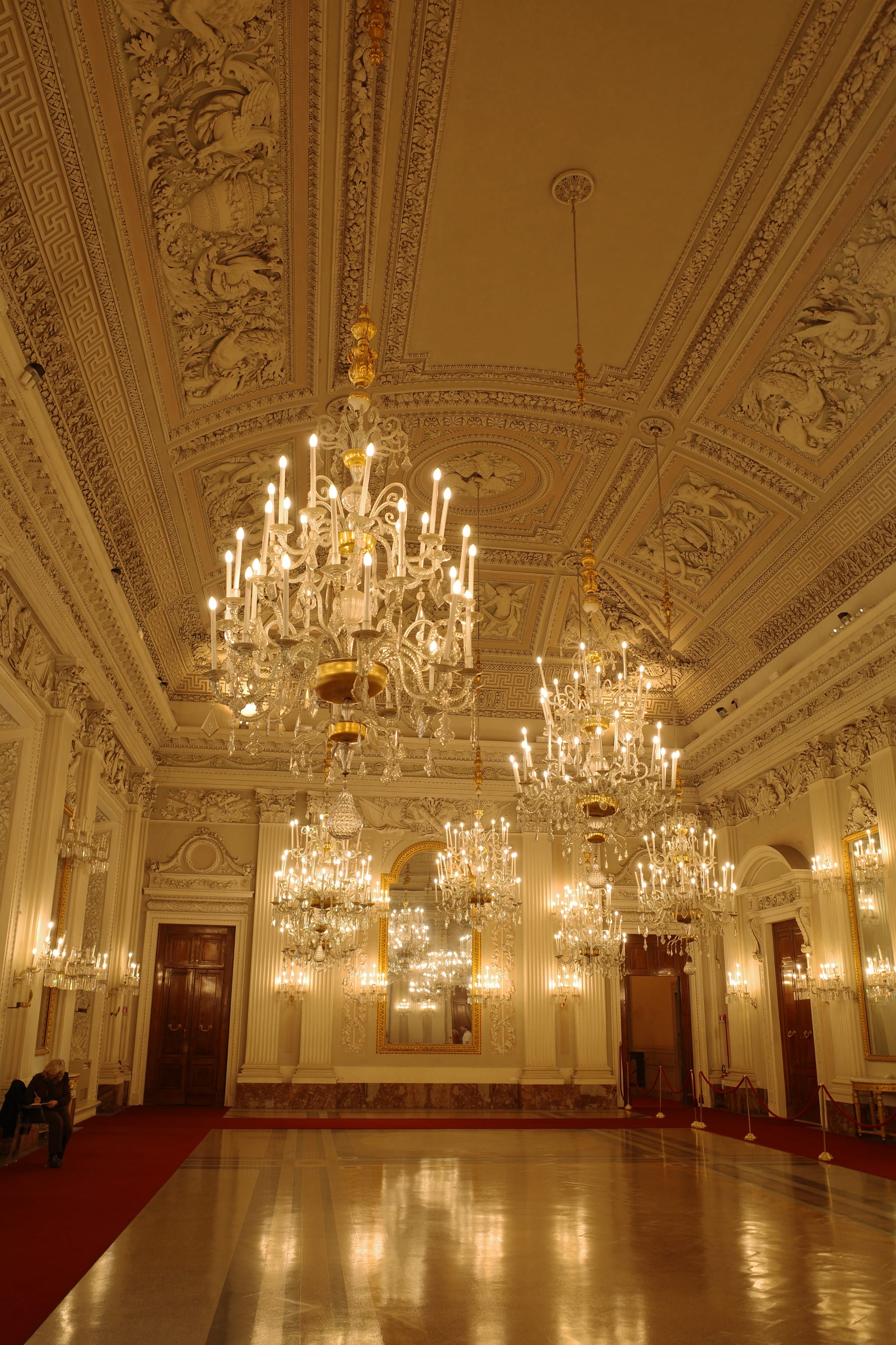 Ornate chandelier and ceiling inside Pitti Palace