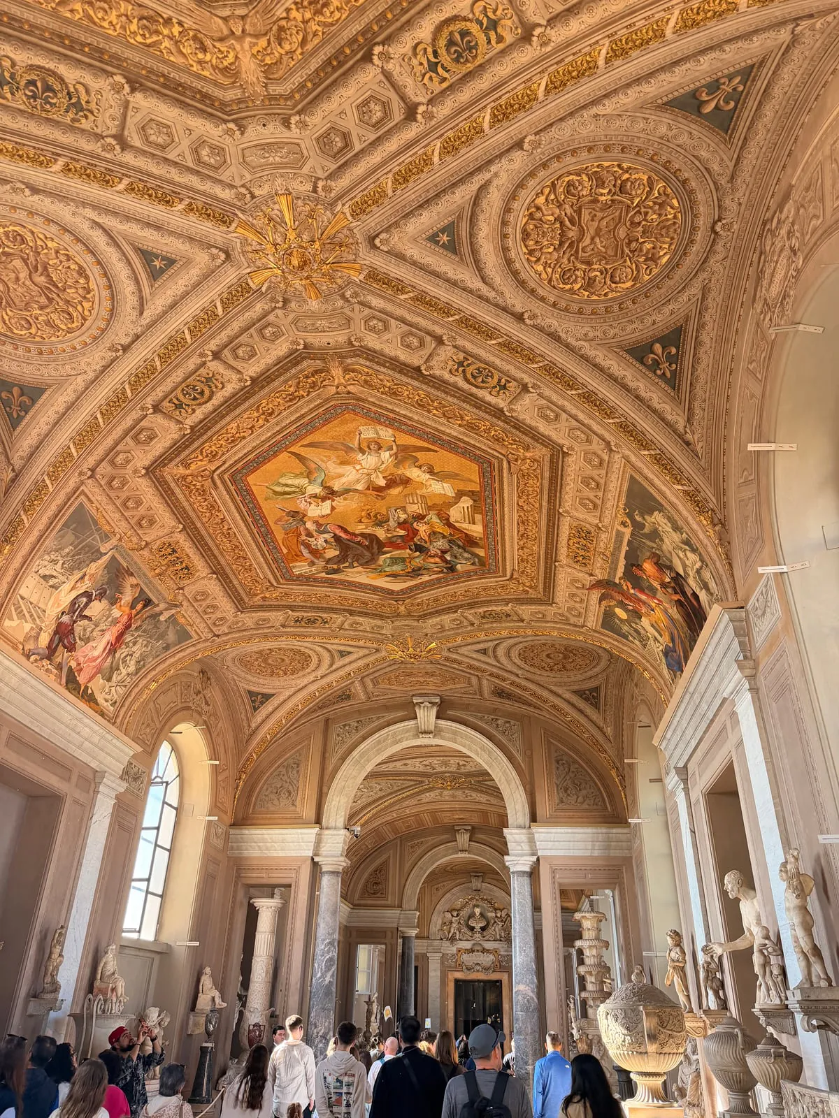 Ornate painted ceiling and sculpture gallery inside the Vatican Museums