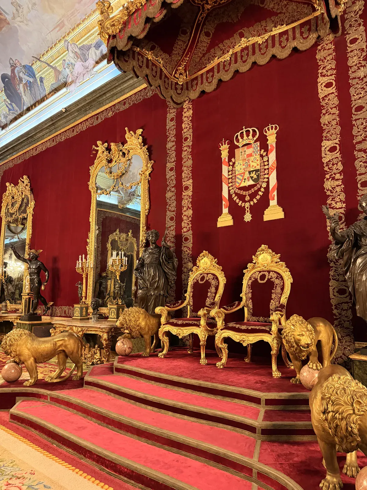 The Throne Room of the Royal Palace of Madrid, with gilded lions flanking the red velvet dais.