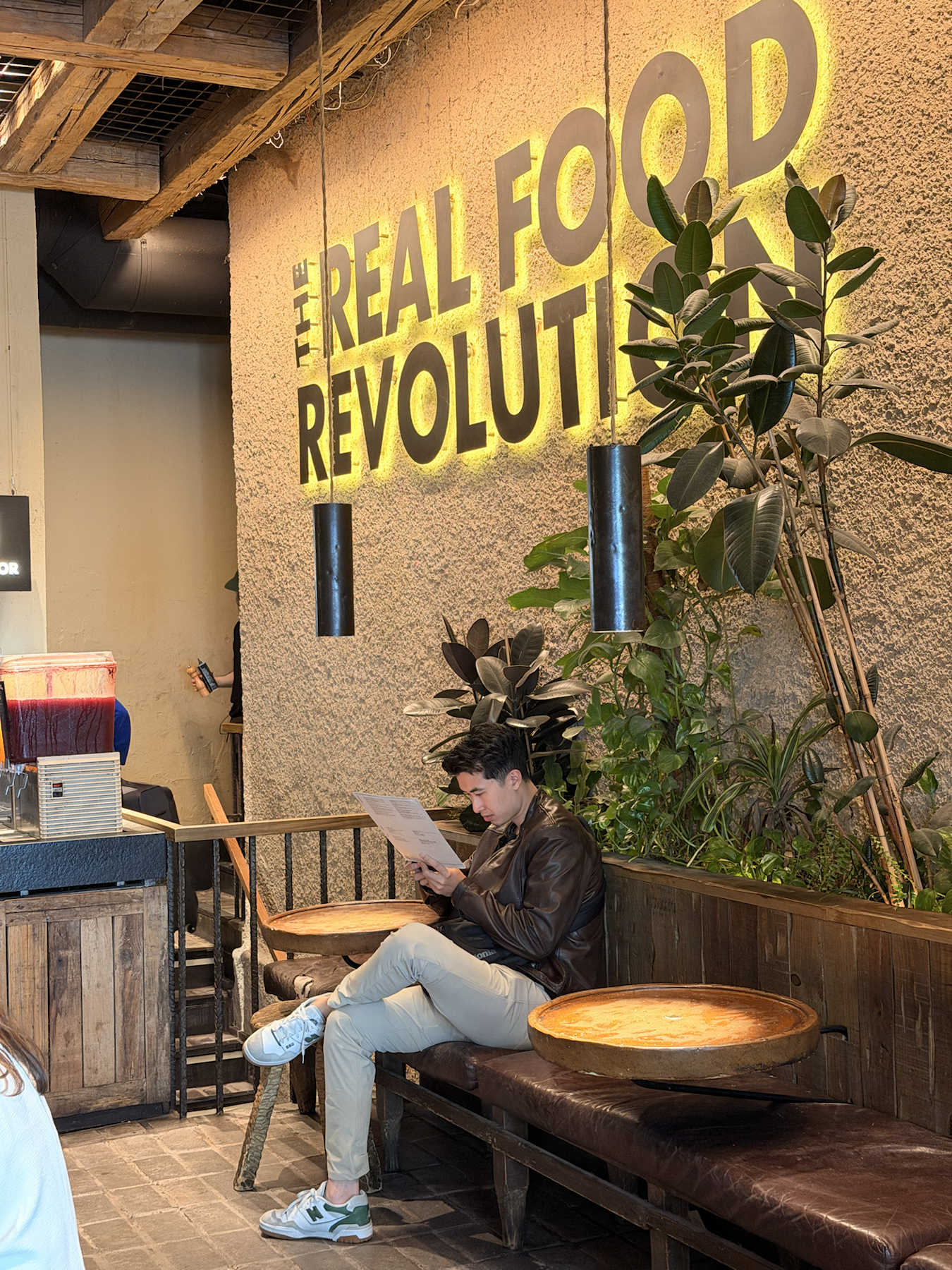 Interior seating area at Honest Greens Madrid with greenery and warm lighting