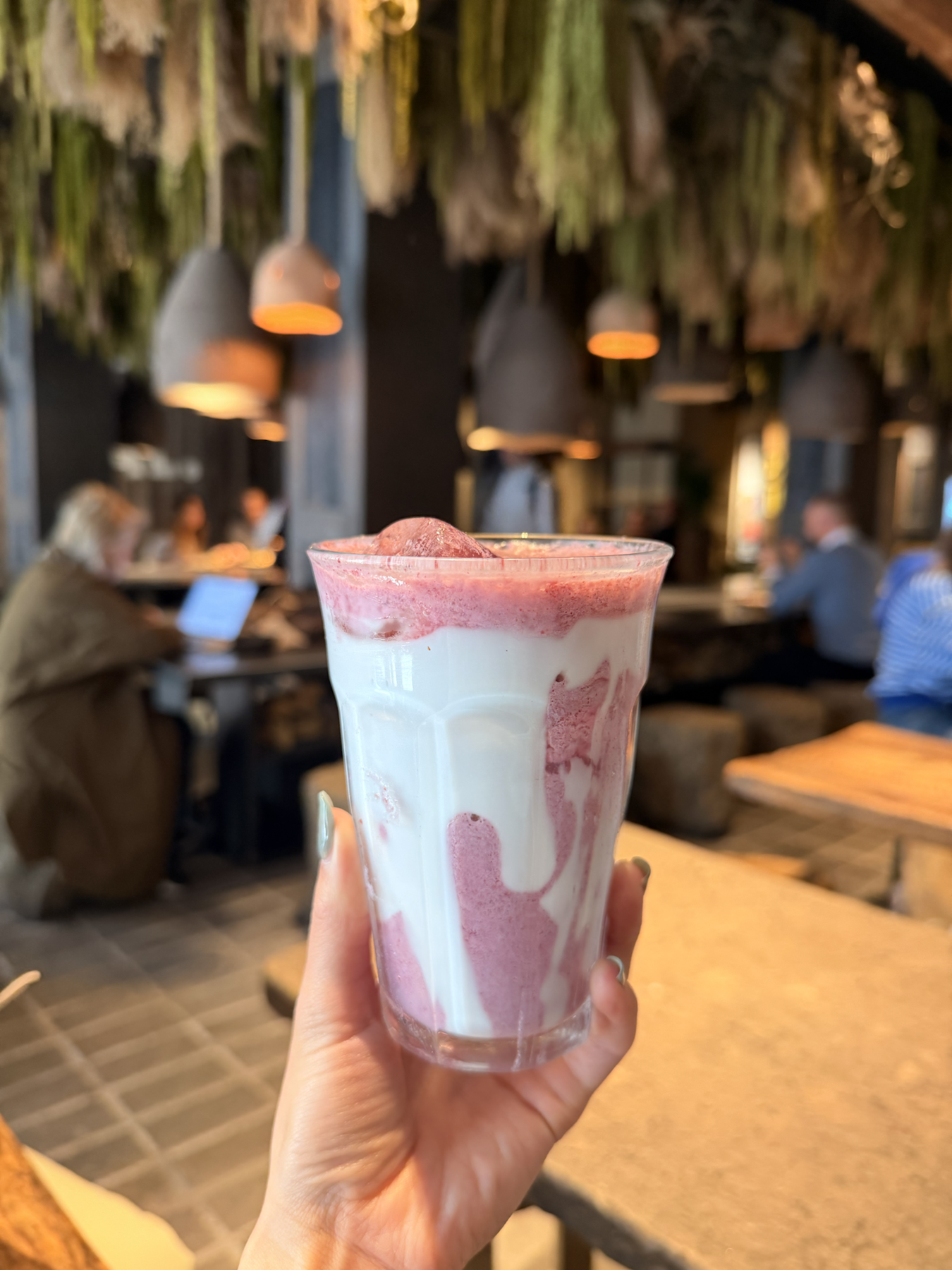 Pink smoothie held inside Honest Greens Madrid