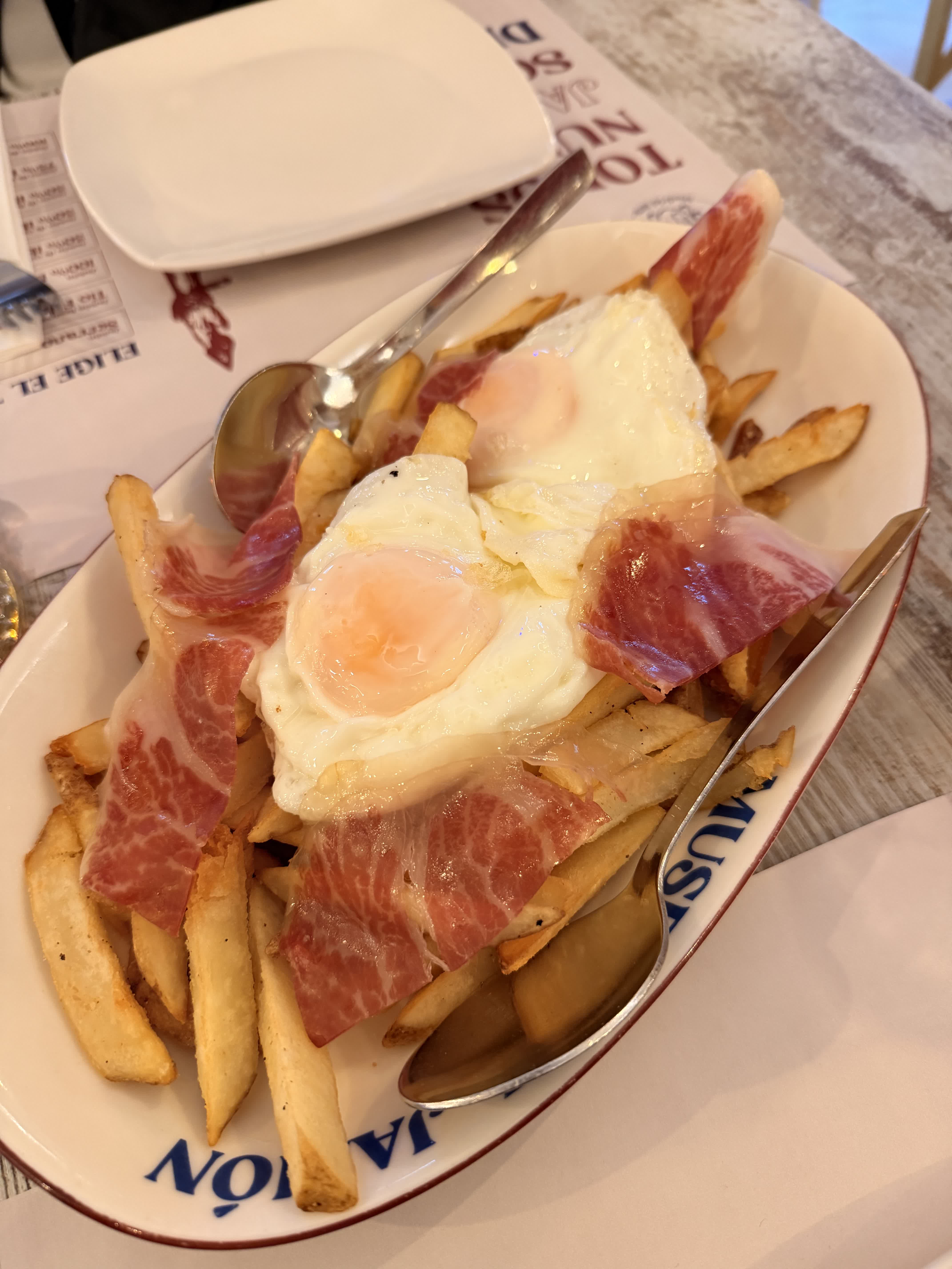 Fries topped with fried eggs and slices of Iberico ham at Museo del Jamon Madrid