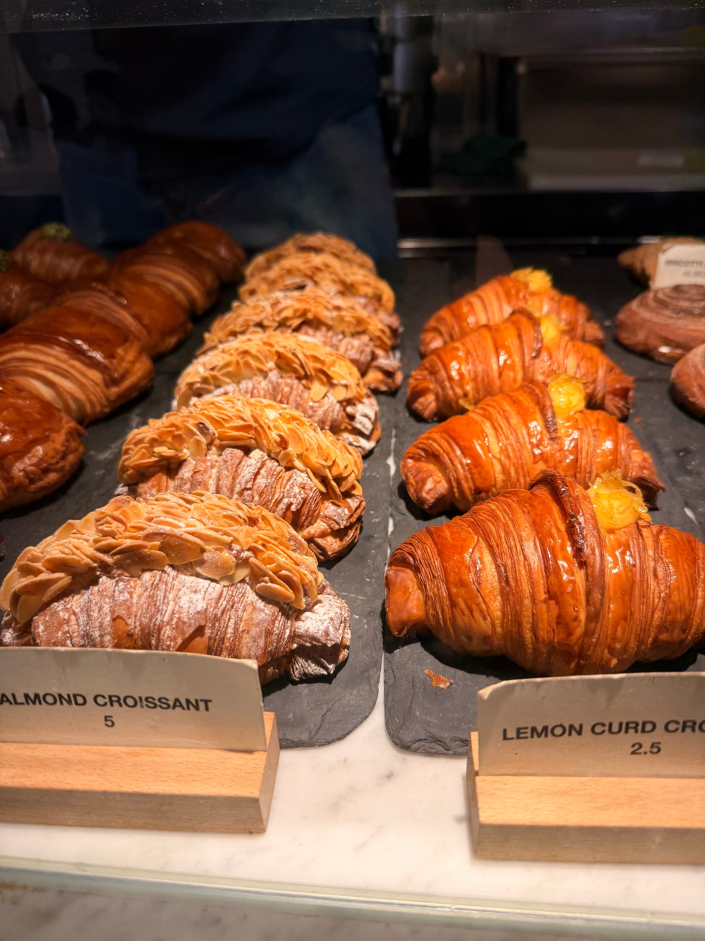 Rows of almond and lemon cornetti in the pastry case at Barnum in Rome