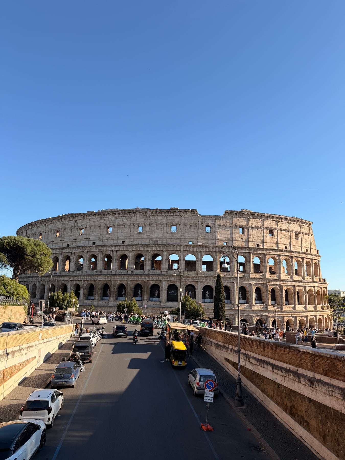 Wide view of the Colosseum exterior under a clear blue sky