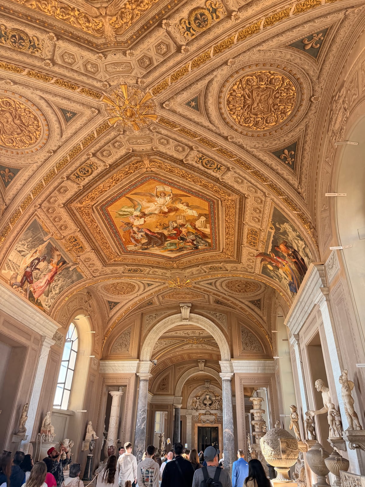 Ornate painted ceiling and sculpture gallery inside the Vatican Museums