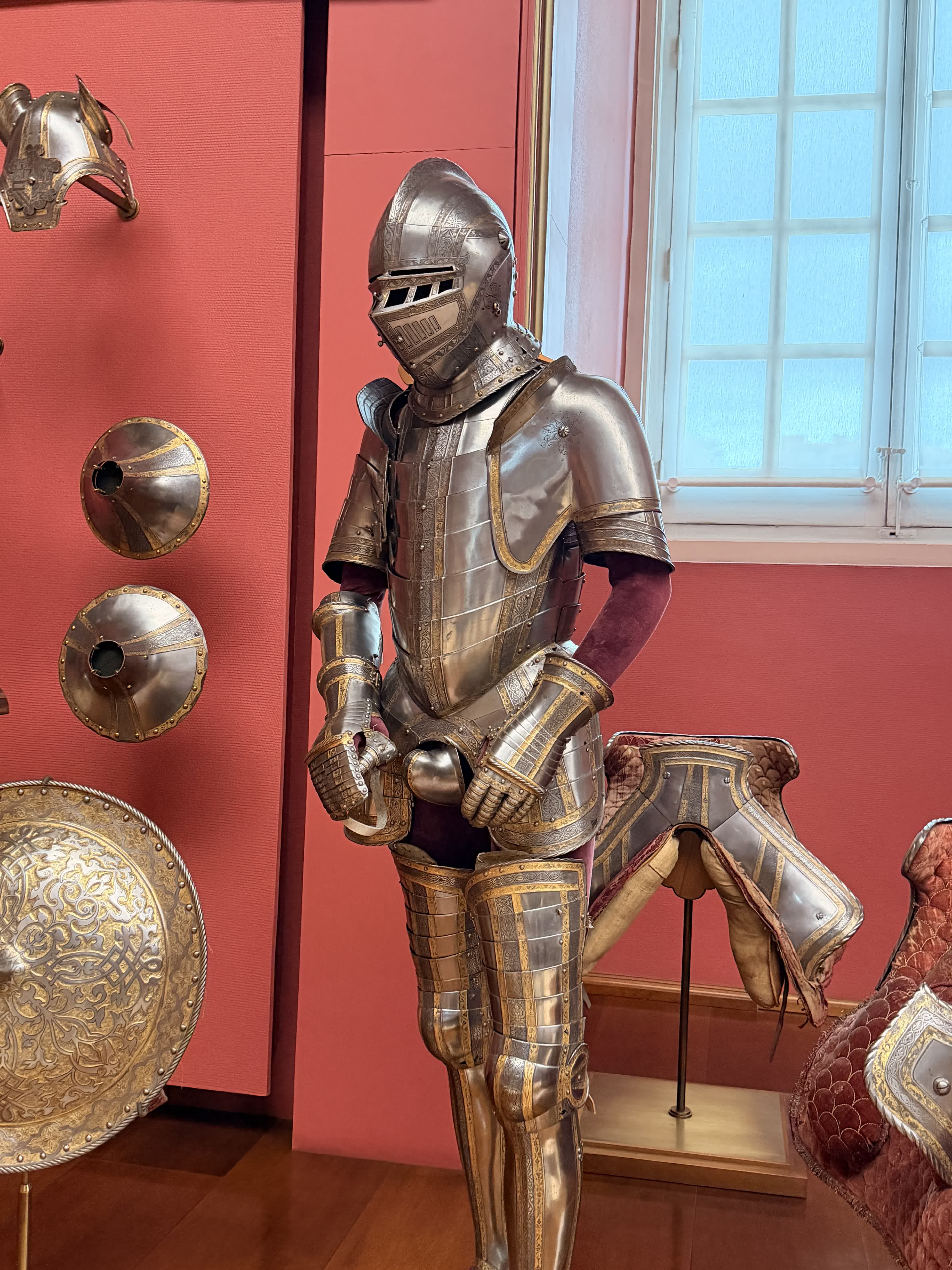 Detailed suit of armor with gilded metalwork inside the Royal Armoury of Madrid