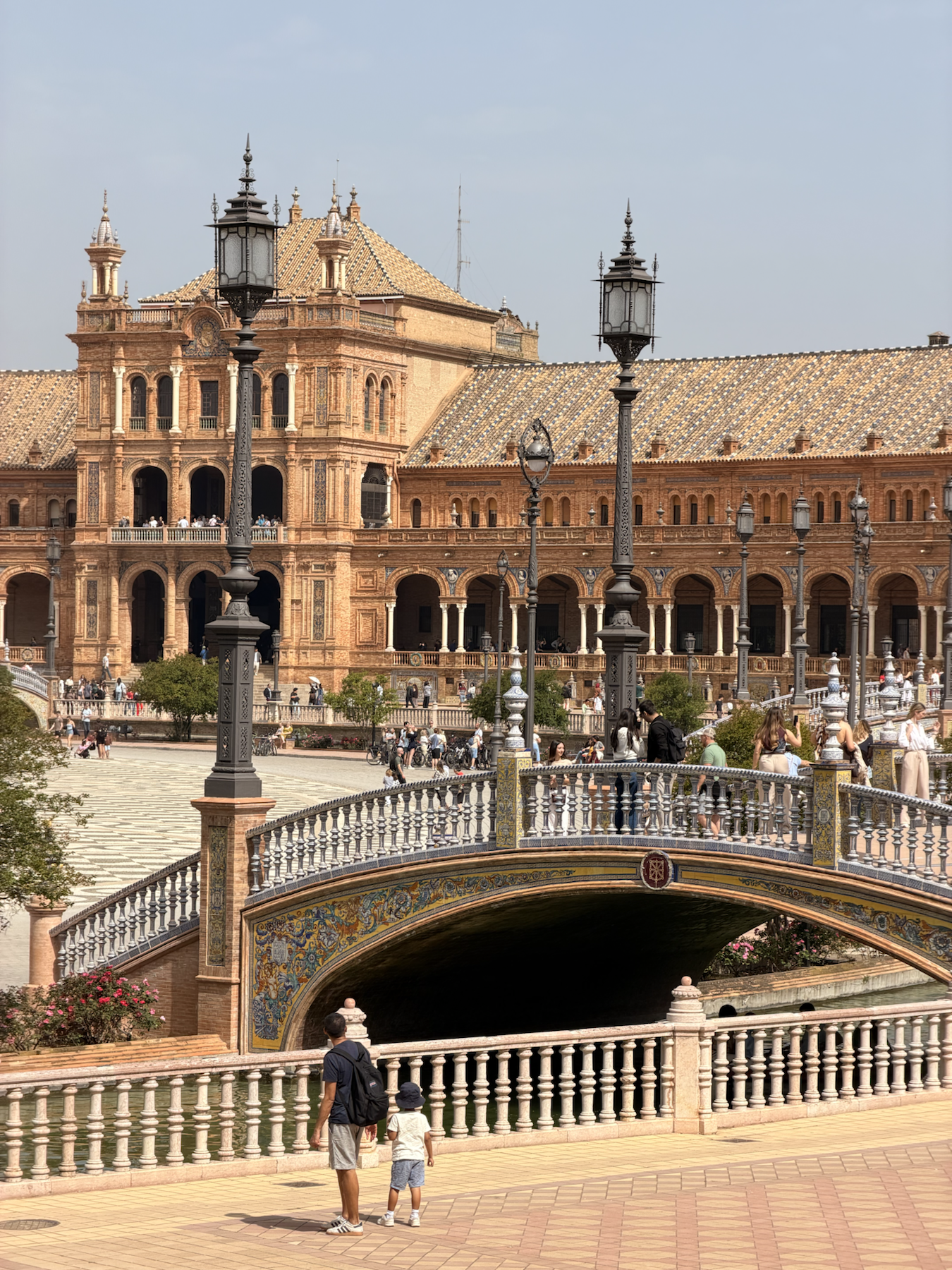 Wide view of a tiled bridge and tower at Plaza de España in Seville