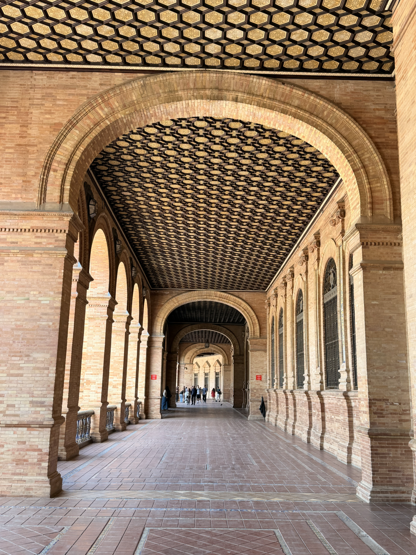 Covered arcade with tiled ceiling details at Plaza de España in Seville