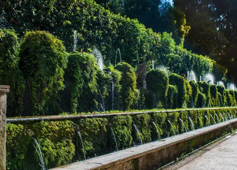 A long wall of fountains and greenery in the gardens of Villa d'Este in Tivoli